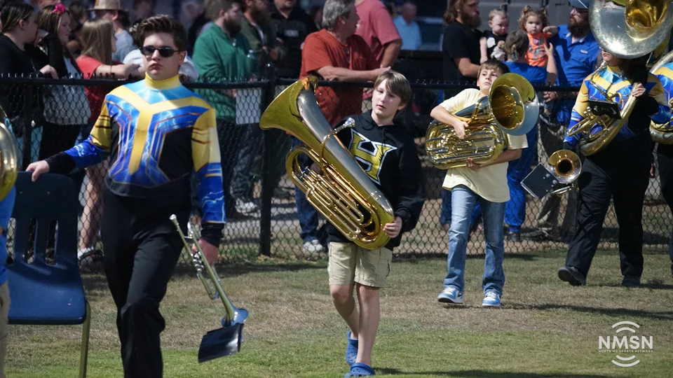 Hatley band members carry their instruments onto the field — Hamilton at Hatley, October 30, 2026. Photo: NMSN.