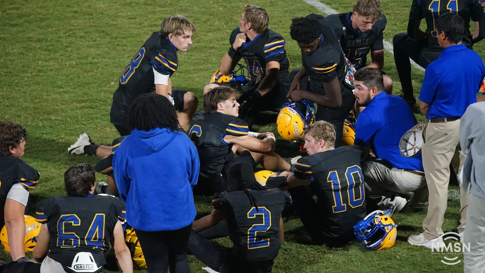 Hatley players listen to coaches in a sideline huddle — Hamilton at Hatley, October 30, 2026. Photo: NMSN.