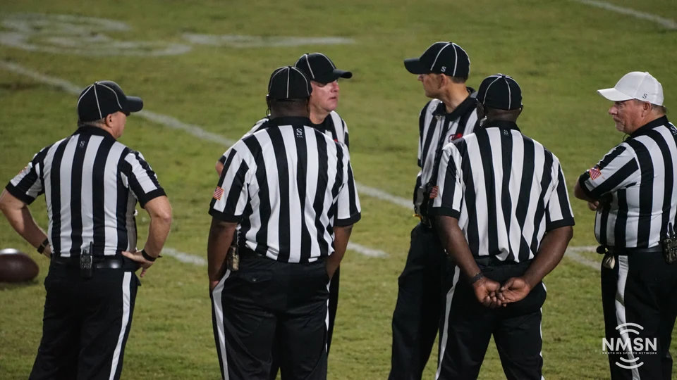 The officiating crew gathers on the field — Hamilton at Hatley, October 30, 2026. Photo: NMSN.