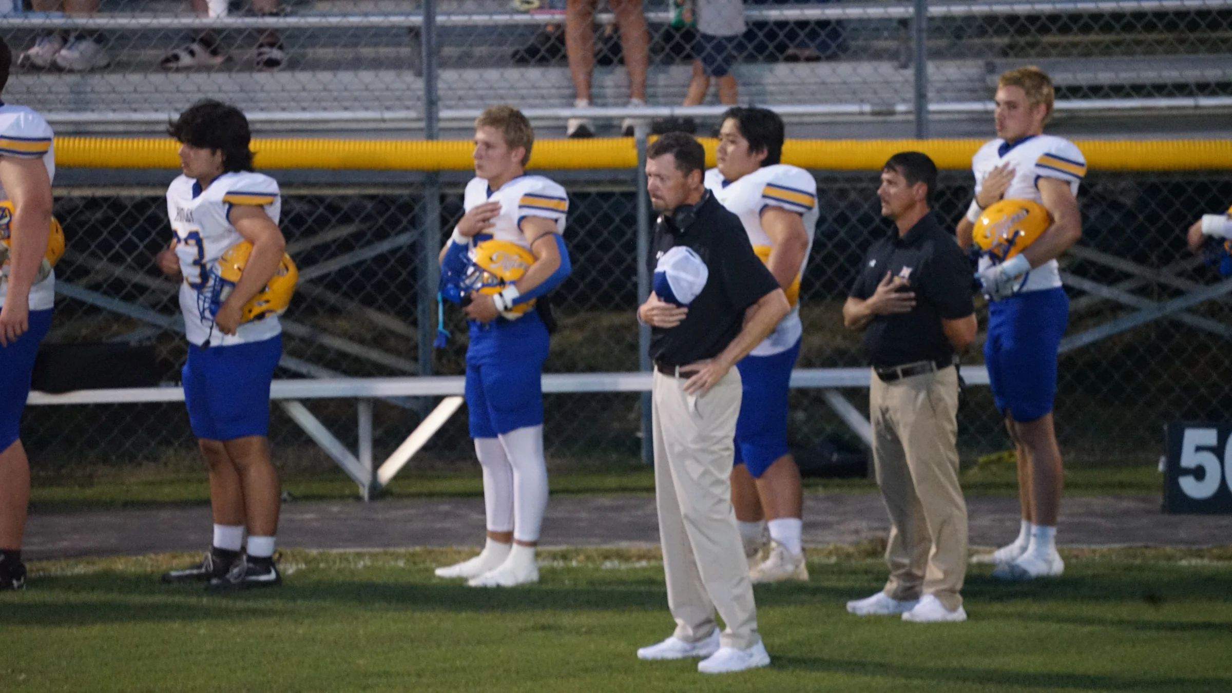 Hatley players and coaches stand for the national anthem before kickoff against Mantachie on September 11 at Mustang Stadium. Photo by Steven Martinez.